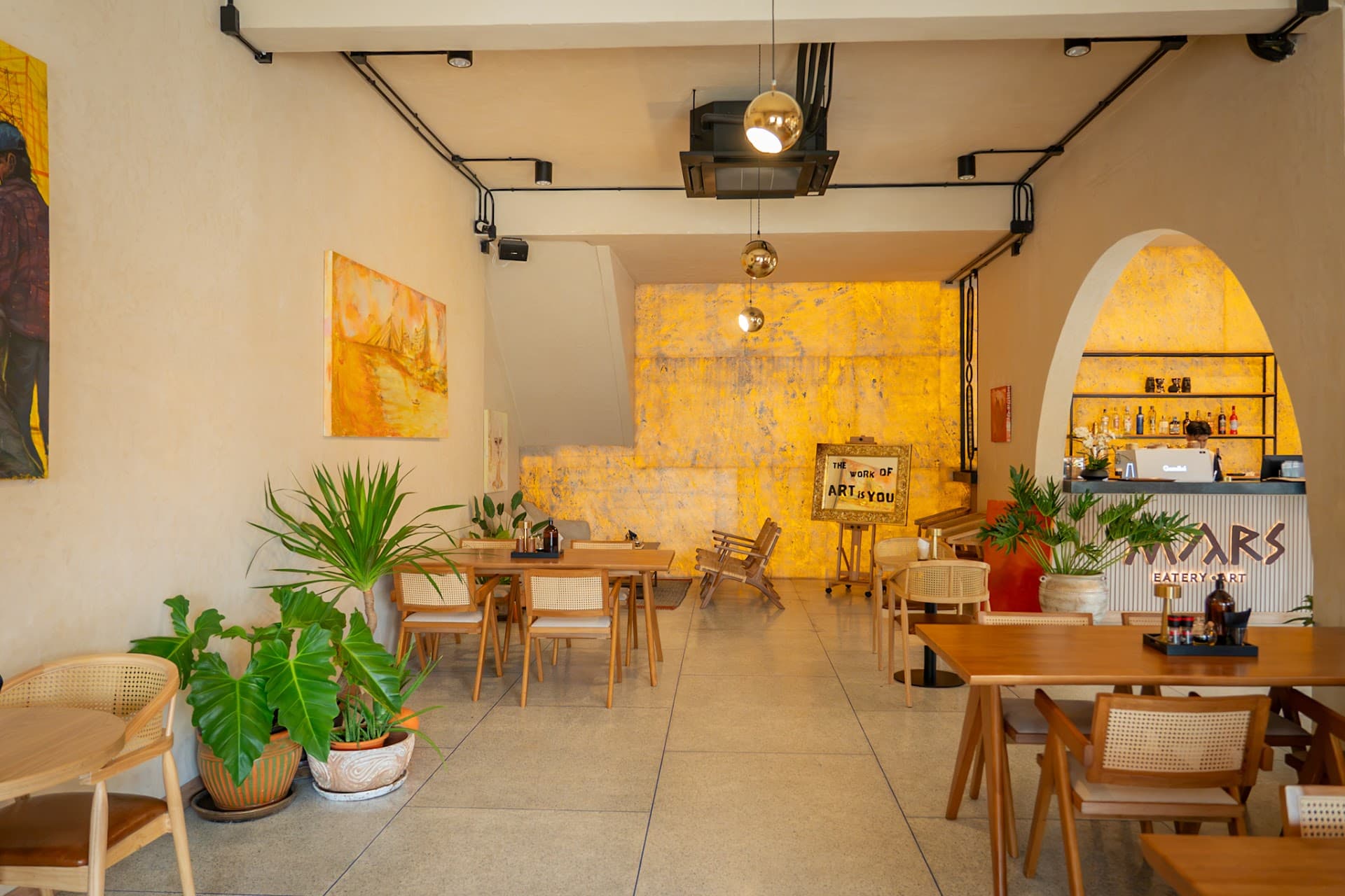 Inside MARS — cream plaster, arches and a golden bar wall