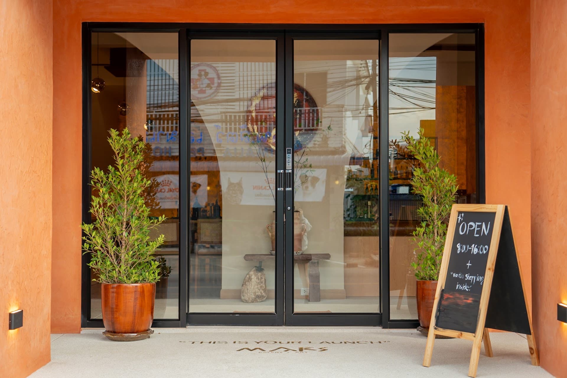 The MARS entrance: black steel doors in a terracotta wall, with an "OPEN" chalkboard